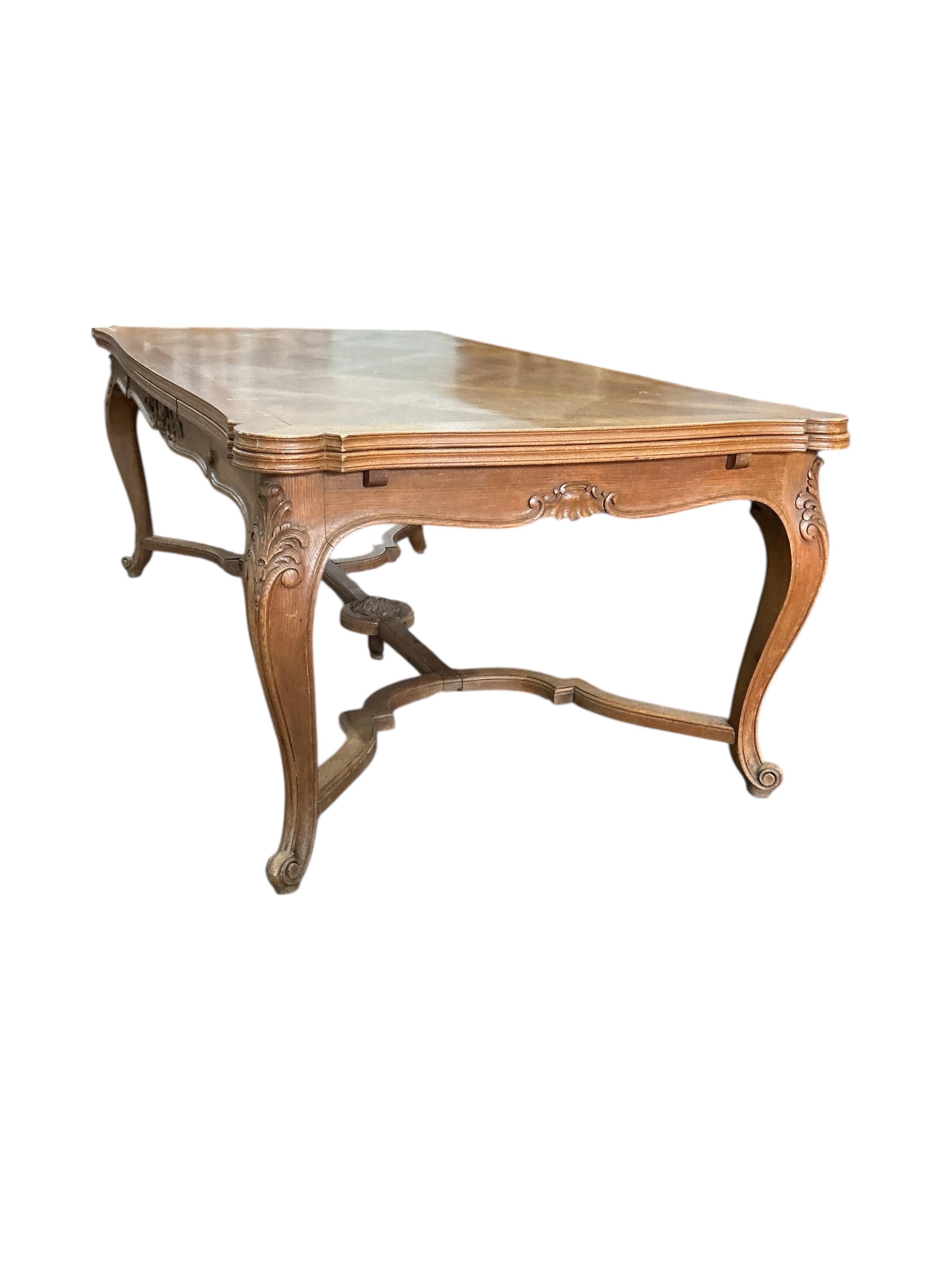 A French rectangular parquetry draw leaf dining table on acanthus carved cabriole legs, width 199cm, (320cm extended), depth 119cm, height 76cm